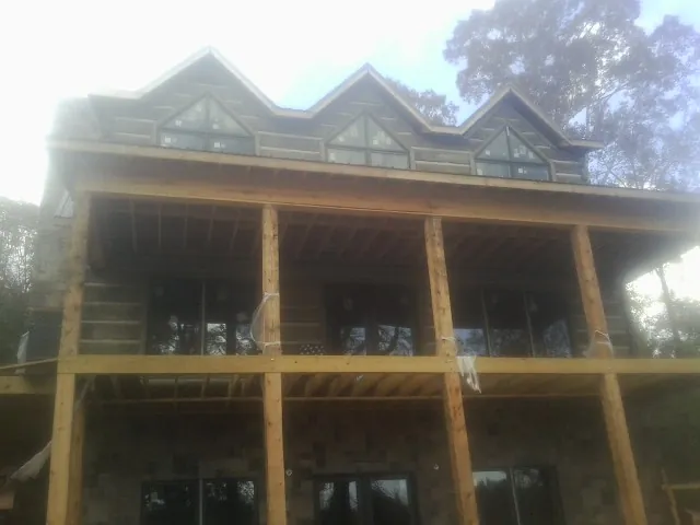 Dormers and porch framing on a large log home under construction — Roof Coating work by our crew in Hayden