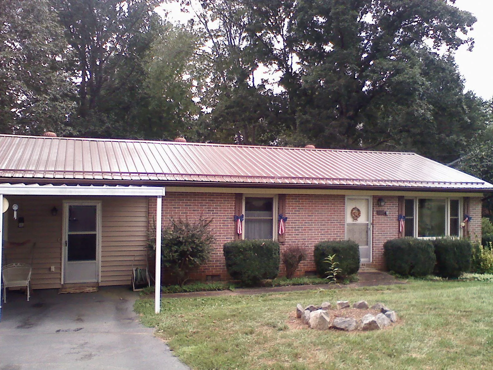 Bronze metal roof and carport on a brick ranch home — Roof Repair work by our crew in Hayden